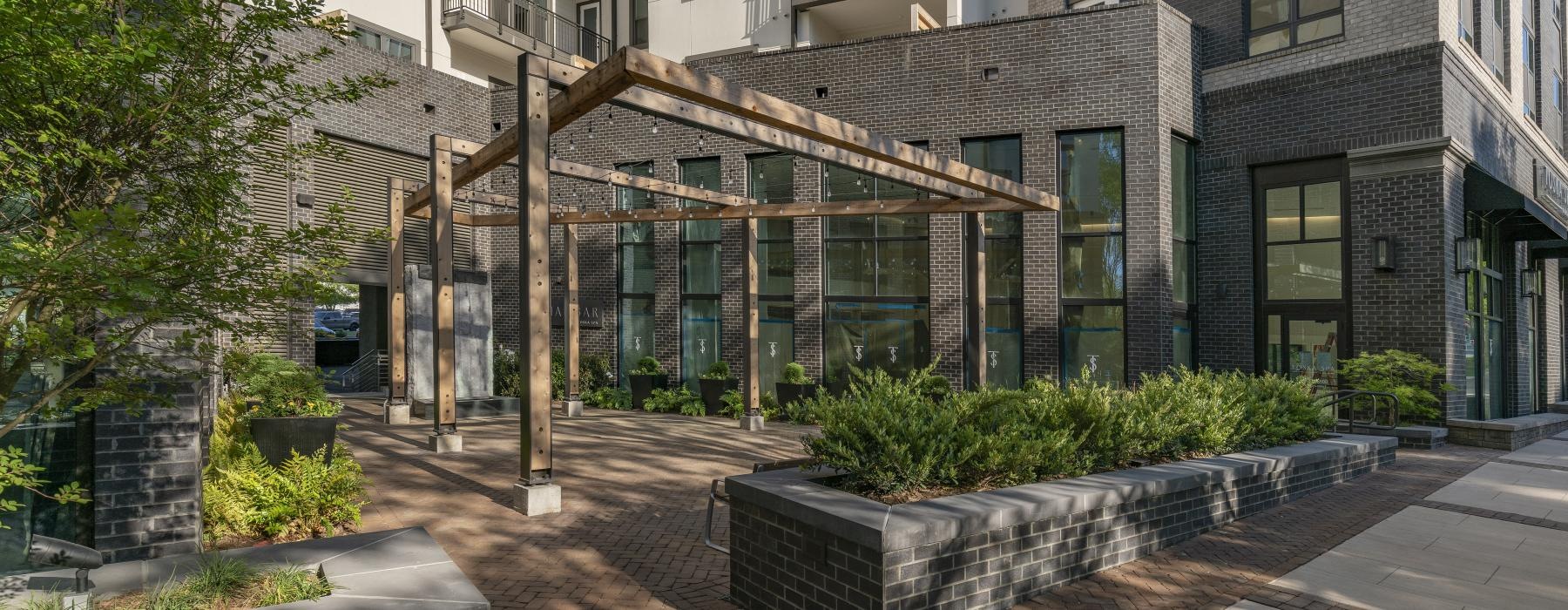 a courtyard with a brick walkway and a building with a glass wall